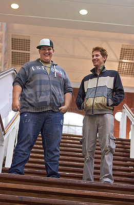 Buy stock photo Students, teenager friends and boys walking down university and school steps with a smile. Conversation, talking and discussion of guy group feeling happy on education building stairs with a talk