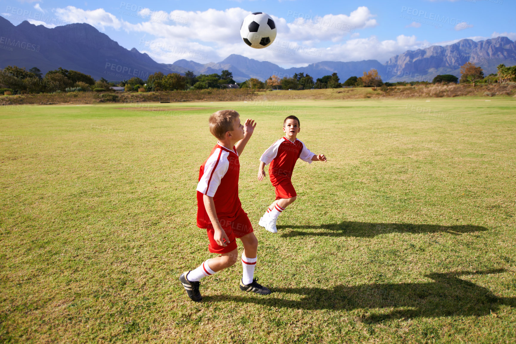 Buy stock photo Children, exercise and playing soccer on field, practice and training for match and game in outdoors. People, kids and fitness or cardio and sports, ball and sportswear or workout together for fun