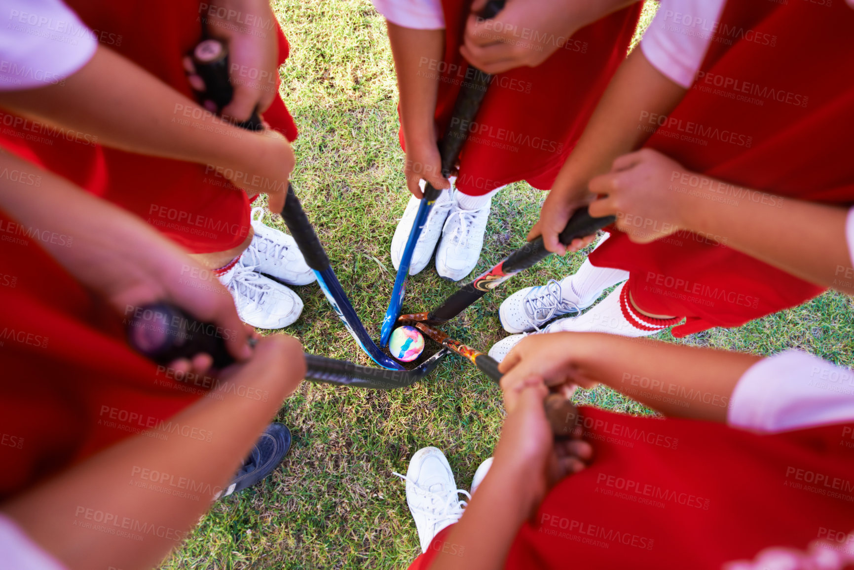 Buy stock photo Children, hockey team and circle above with ball on green grass for sports, match or game together. Top view closeup of kids, player hands and huddle on field for teamwork or outdoor unity in nature