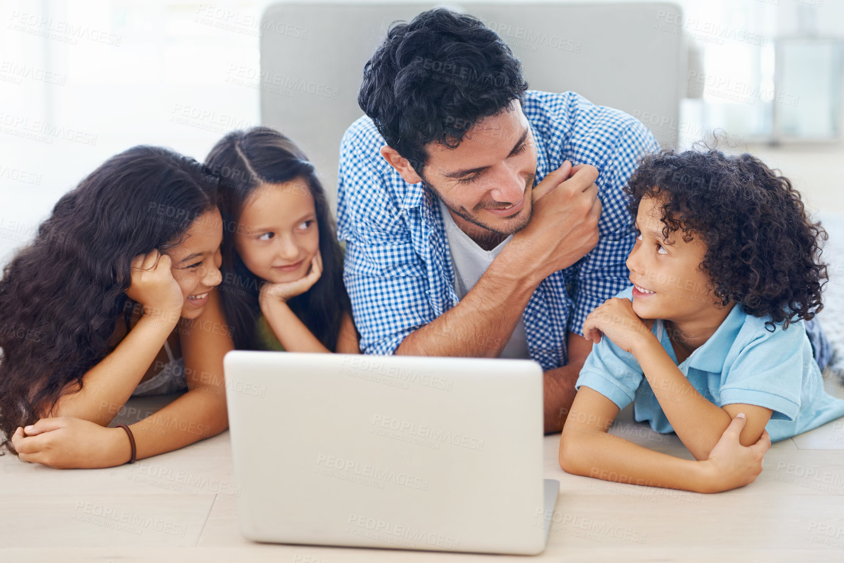 Buy stock photo Shot of a smiling family lying on the floor and surfing the internet