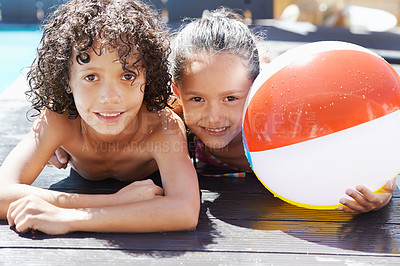 Buy stock photo Portrait of two children lying by a swimming pool on a sunny day