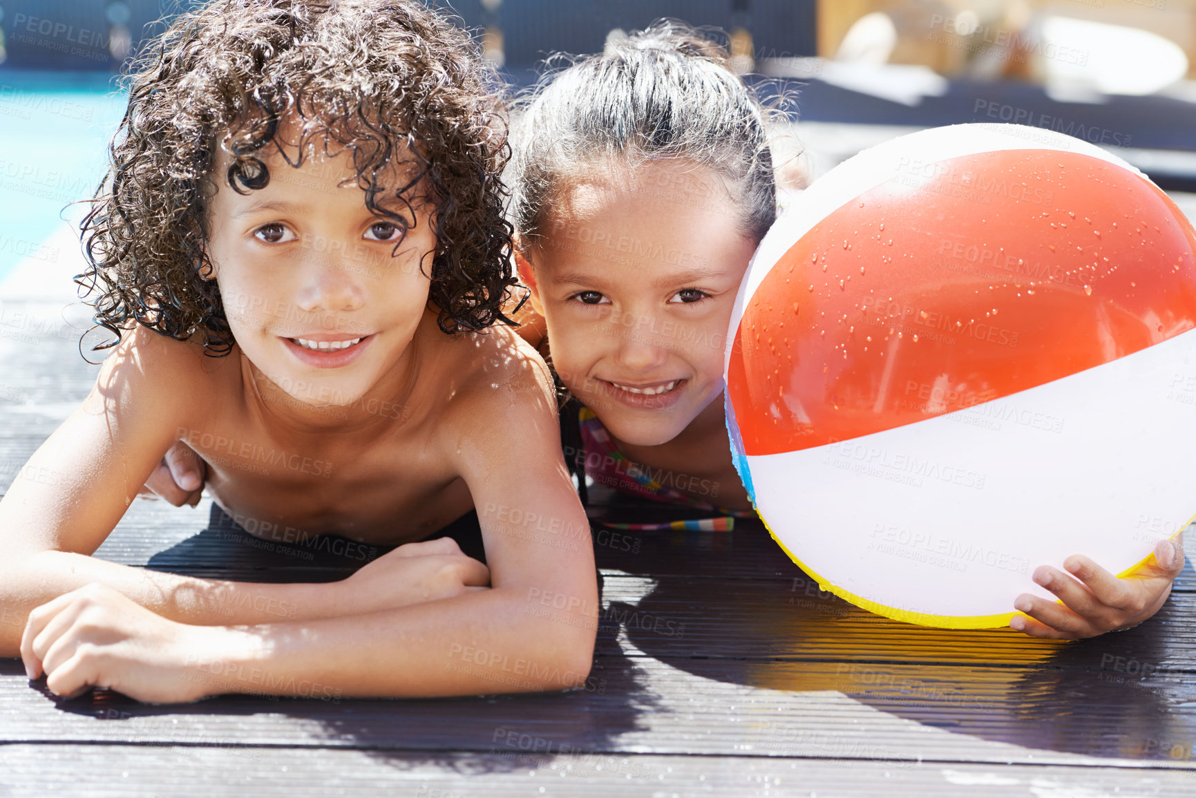 Buy stock photo Portrait of two children lying by a swimming pool on a sunny day