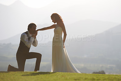 Buy stock photo Couple, garden or kiss on hand in wedding for outdoor celebration, care or ceremony event. One knee, romantic groom or proud bride in bridal garment for commitment, love or marriage in park for space