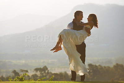 Buy stock photo A groom carrying his bride