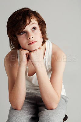 Buy stock photo Thinking, fashion and boy child in a studio with dreaming, reflection or memory face expression. Youth, style and young kid model with casual, stylish and trendy outfit isolated by gray background.