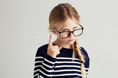 Buy stock photo Strict, serious and portrait of a child with a gesture isolated on a white background in a studio. Rude, smart and a young girl wearing glasses and gesturing with finger for discipline on a backdrop