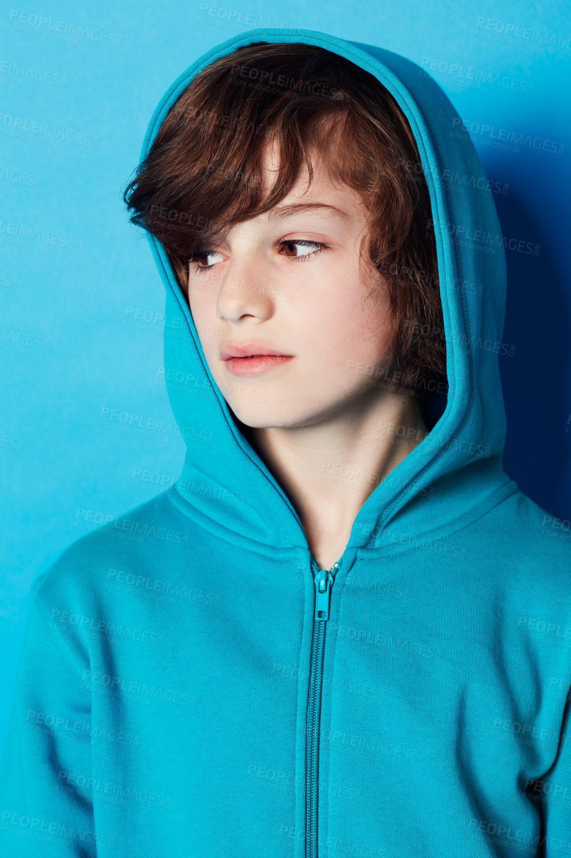 Buy stock photo Studio, fashion or young kid in hoodie, trendy apparel or stylish outfit isolated on blue background. Cotton fabric, adolescent boy and youth child with clothes, casual outfit and looking at style