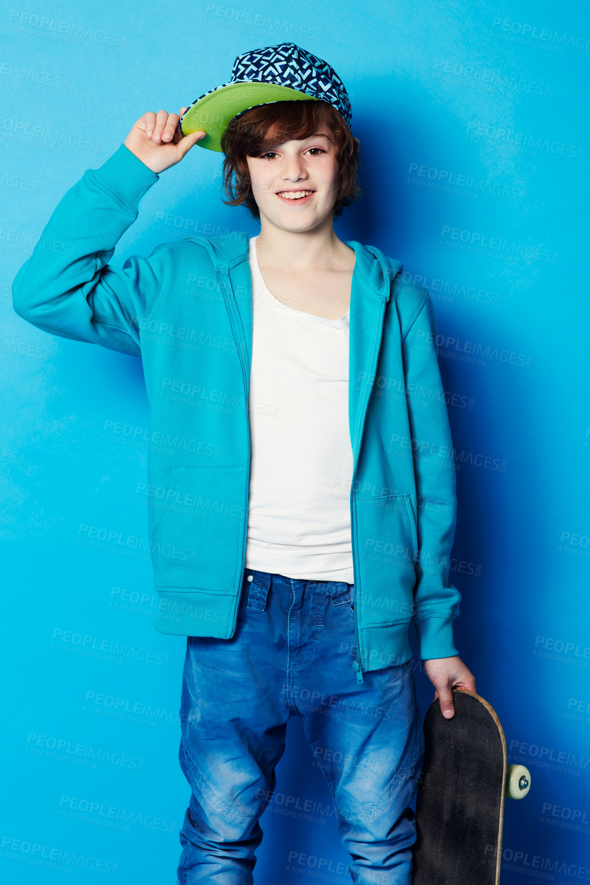 Buy stock photo Fashion, skateboard and portrait of a child in a studio with a casual, trendy and cool outfit. Skateboarder, smile and happy boy kid model with skating style posing isolated by a blue background.