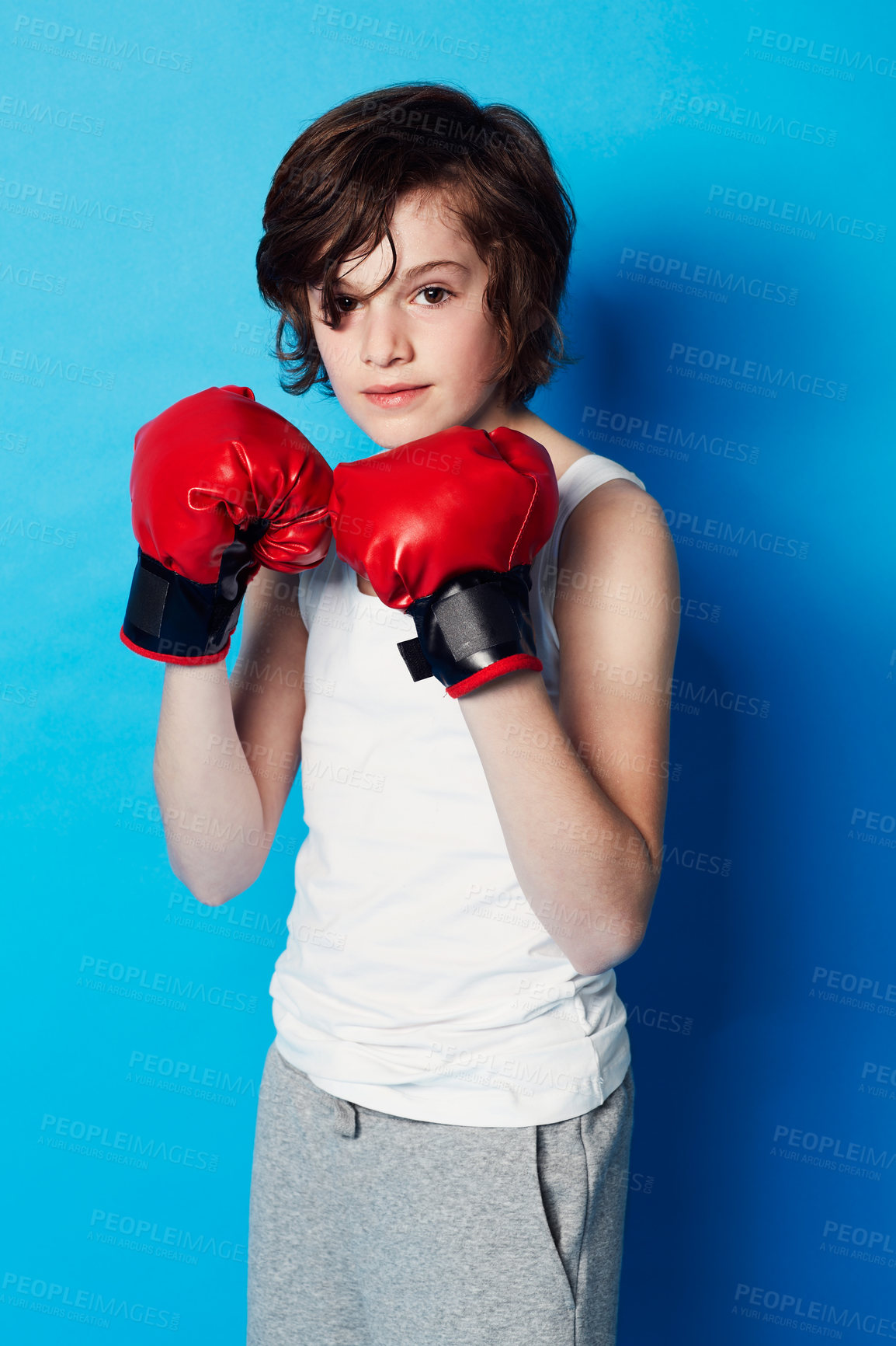 Buy stock photo Portrait of a young boy wearing boxing gloves in the studio