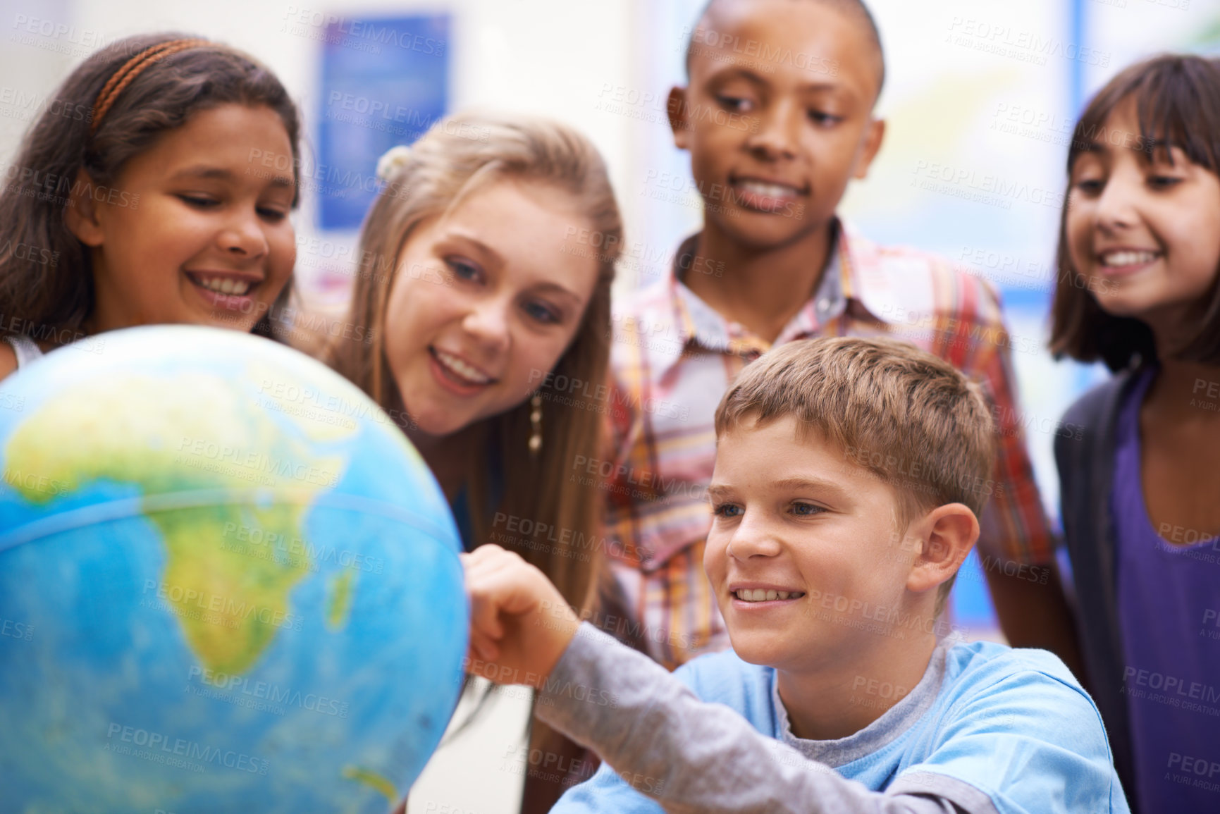 Buy stock photo A group of pupils looking at a globe during geography class
