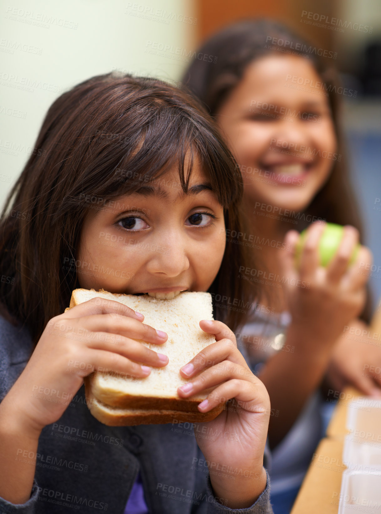 Buy stock photo Hungry girl, portrait and student eating sandwich in classroom at school for meal, break or snack time. Young kid or elementary child biting bread for lunch time, fiber or nutrition in class recess