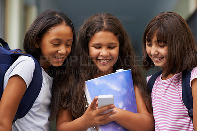 Buy stock photo Elementary school, friends and happy girls with phone for social media, digital education or download elearning tech. Diversity, young students or kids typing on mobile for studying, knowledge or app