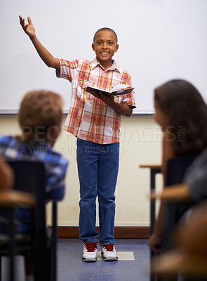 Buy stock photo A young boy doing prepared reading at the front of the class