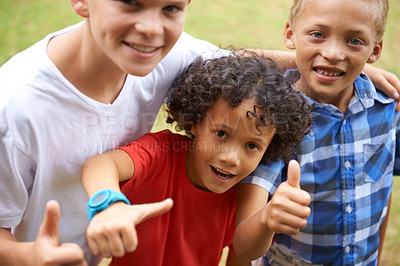 Buy stock photo Happy children, portrait and thumbs up at park for teamwork, winning or good job together in nature. Group of casual young boys smile and hug with like emoji, yes sign or OK for outdoor success