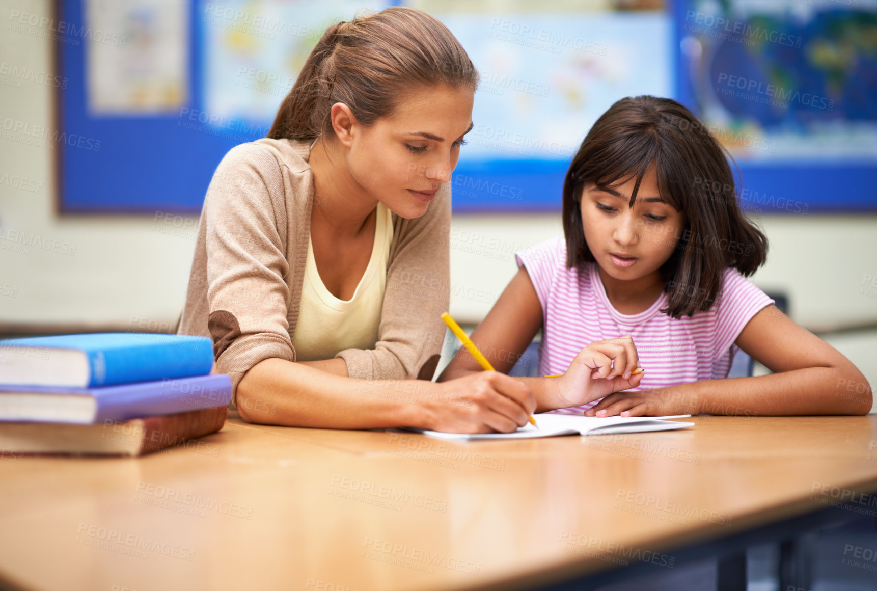 Buy stock photo Shot of a teacher helping her student with her work in the classroom