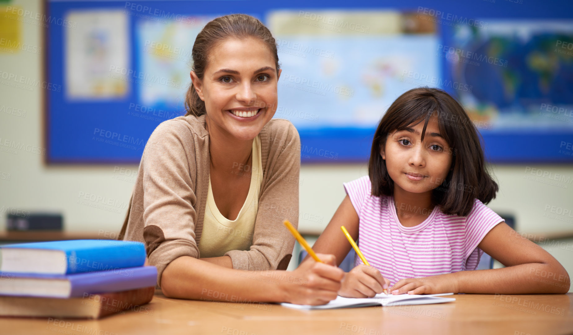 Buy stock photo Shot of a teacher helping her student with her work in the classroom