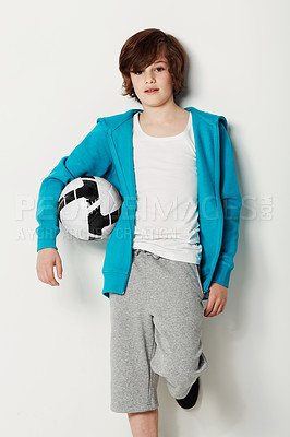 Buy stock photo Football, casual and portrait of teenager in a studio for sports training or exercise with style. Serious, fashion and boy kid athlete with soccer confidence and trendy outfit by white background.