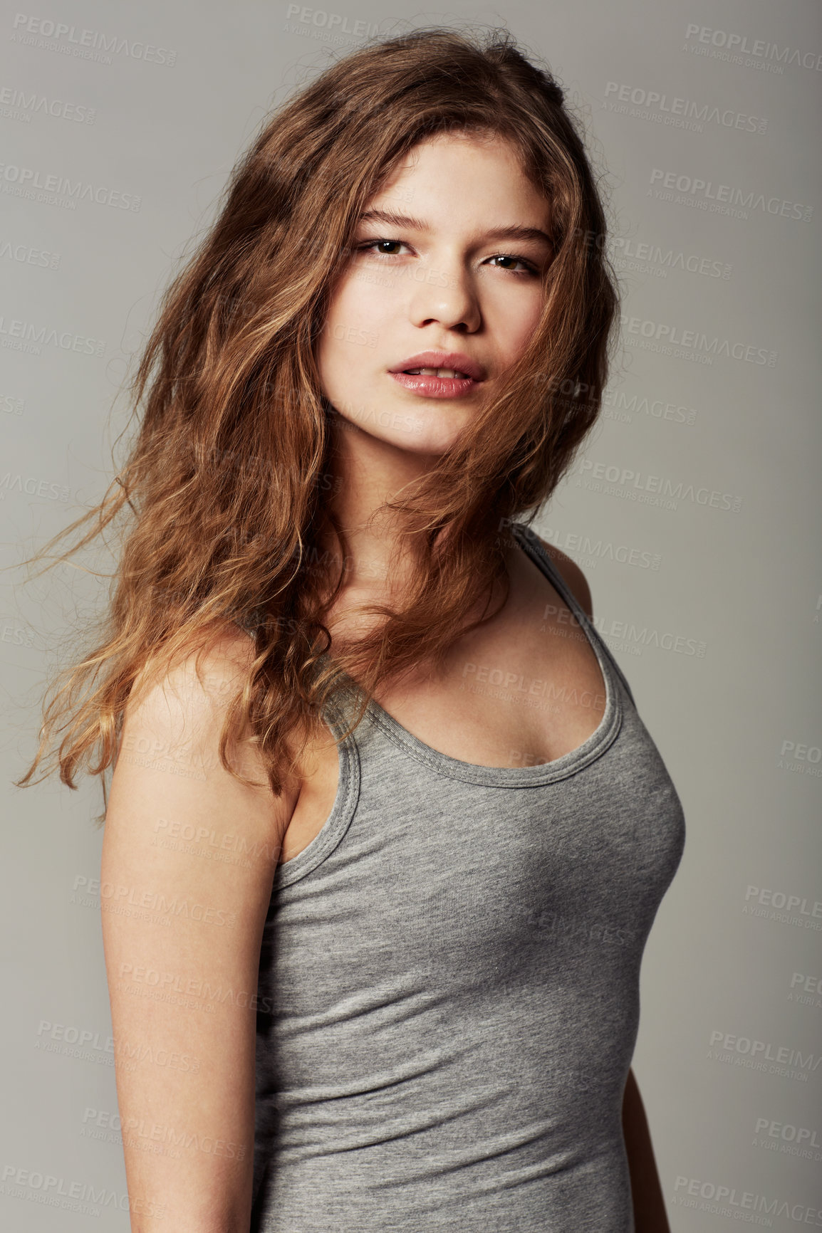 Buy stock photo Portrait of an attractive young teenage girl standing against a gray background