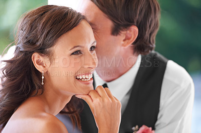 Buy stock photo Happy couple, groom and whisper as secret on wedding day, romance and happy for commitment. People, gossip and privacy or confidential information at ceremony, funny joke and laughing in outdoors