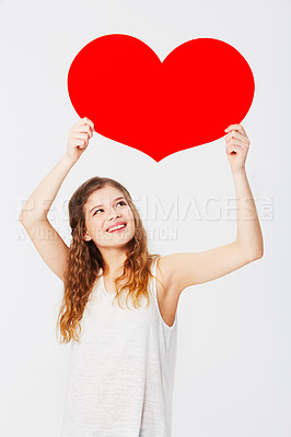 Buy stock photo Love, showing and girl with a cardboard heart isolated on a white background in a studio. Smile, care and happy woman holding a paper shape for romance, attraction and valentines day on a backdrop