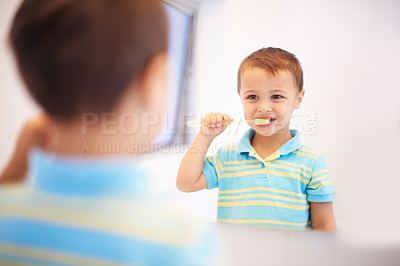 Buy stock photo Boy child, brushing teeth and mirror in bathroom for cleaning, hygiene or health for routine in home. Kid, toothbrush or reflection for dental wellness, smile or results in morning at family house