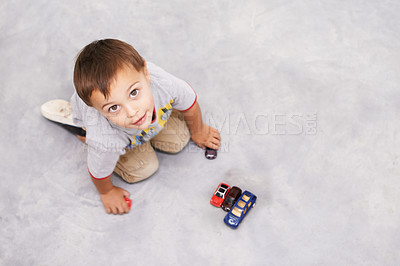 Buy stock photo Car, toys and portrait of kid playing for learning, development and fun at modern home. Cute, top view and sweet young boy child enjoying game with vehicles on floor for childhood hobby at house.