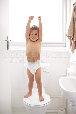 Buy stock photo Shot of a happy young boy in a diaper standing on a toilet seat