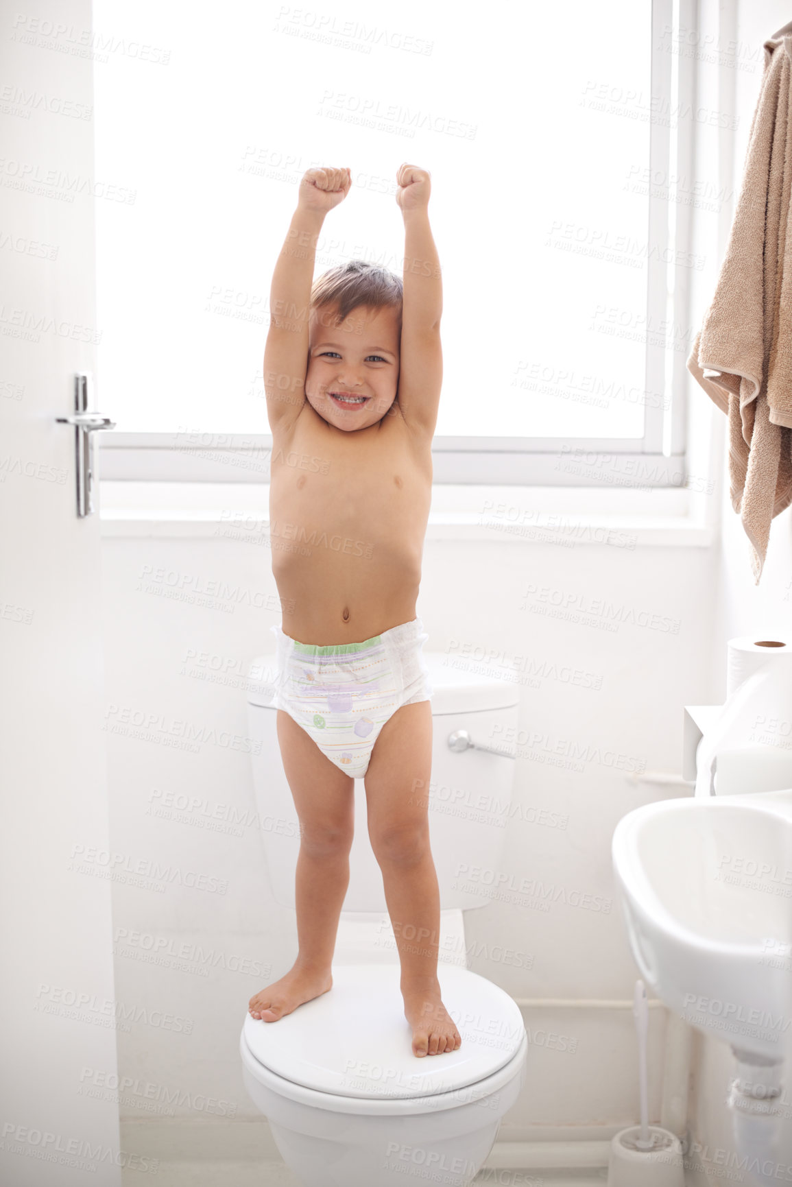 Buy stock photo Shot of a happy young boy in a diaper standing on a toilet seat