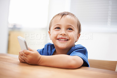 Buy stock photo Toddler, boy and texting at home, happiness and communication with technology. Table, chatting and conversation for learning, cellphone and excited for child development, mobile phone and digital