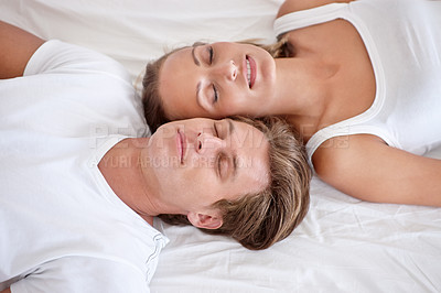 Buy stock photo Sleeping, love and young couple on bed in modern apartment relaxing together in the morning. Happy, calm and man and woman in marriage taking comfortable nap for dreaming in bedroom at home or house.