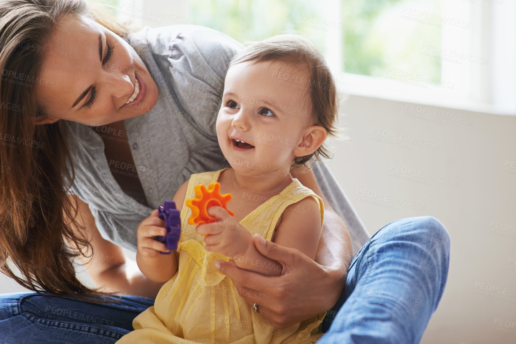 Buy stock photo Shot of a cute baby girl sitting on the floor with her mom and playing with toys