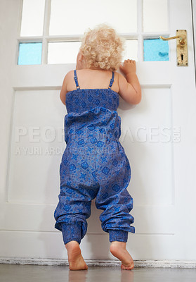 Buy stock photo A cute little girl peeking out of th front door's window