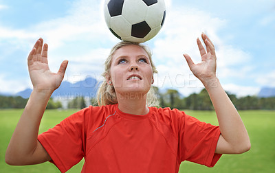 Buy stock photo Shot of a young female soccer player balancing a ball on her head