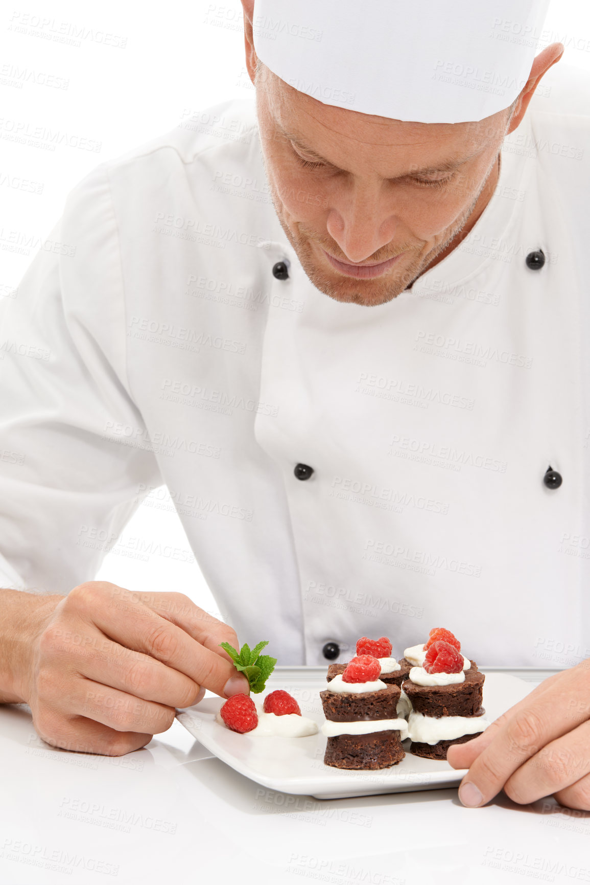 Buy stock photo Cook, dessert and mint on sweet chocolate or berries on food by culinary chef with recipe on a plate in white studio background. Cooking, presentation and man or person making mini cakes as cuisine