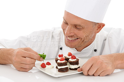 Buy stock photo Baking, smile and chef with a dessert for catering isolated on a white background. Cooking, professional and man plating a chocolate cake and fruit on a plate for a food service on a backdrop