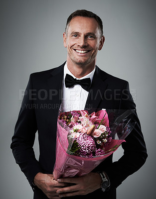 Buy stock photo Portrait, man and bouquet of flowers, suit and happiness for Valentines day, romance and on grey studio background. Face, male and guy with floral gift, smile and gesture for love, romantic and happy