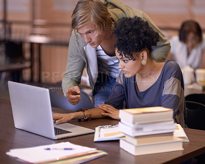 Buy stock photo University, online and students in library on laptop for internet research, studying and learning. Education, college and man and woman with textbooks, computer and reading website for knowledge