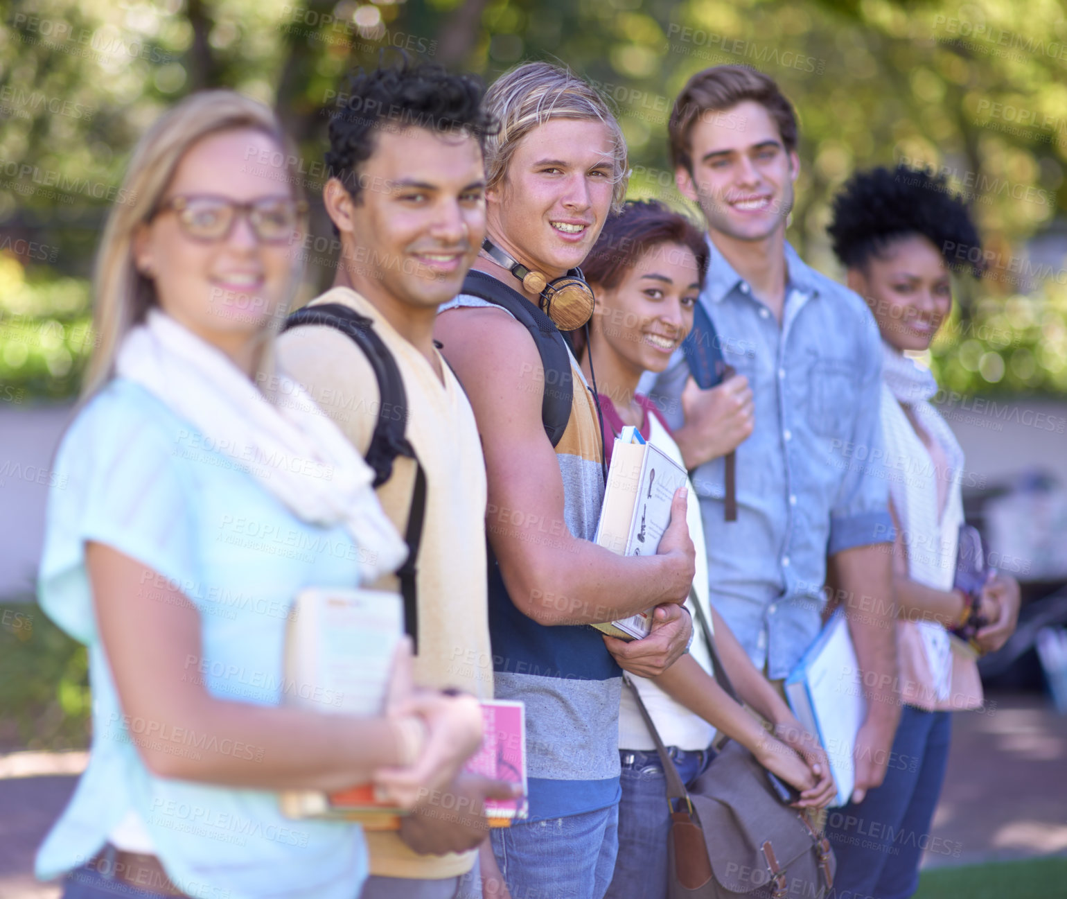 Buy stock photo Students, portrait and happy on campus, row and scholarship opportunity at university with books. Friends, face and diversity in education in learning and study group in college park with commitment