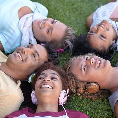 Buy stock photo Friends, headphones and group relax on grass at park, listening to music or radio in summer. Audio, smile and students on lawn in top view, nature and young people streaming sound together outdoor