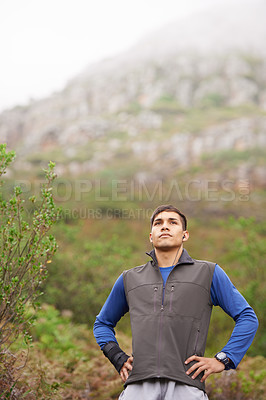 Buy stock photo Man, hiking and earphones for music, mountain and thinking for adventure, exercise or workout. Hiker, fitness and young for training, forest and nature to explore, hobby and heart health in outdoors
