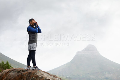 Buy stock photo Shot of a young man shouting on a mountain top
