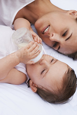 Buy stock photo Above, care and a mother with a baby and milk for nutrition, health and growth development. Morning, family and a young mom and child with a bottle in the bedroom of a house for food and a drink