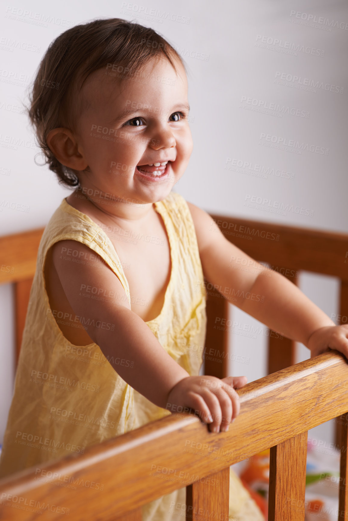 Buy stock photo Cute, laughing and a child in a crib for playing, wake up or comfort in a bedroom. Happy, baby and a young kid in a nursery or room for thinking, idea or innocent standing for development in a home