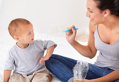 Buy stock photo Bonding, bed and mother feeding baby porridge for health, wellness and nutrition breakfast. Child development, eating and young mom with boy kid, infant or toddler enjoying a meal in bedroom at home.