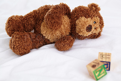 Buy stock photo Teddy bear, closeup and toys in bedroom with building blocks on a mattress for still life of development. Learning, letters and objects for childcare and play in home with plush animal and alphabet