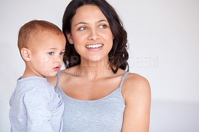 Buy stock photo Family, happy and mom with baby on a white background for bonding, relationship and relax together. Love, youth and portrait of mother carrying kid for growth, playing and child development in studio