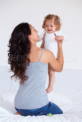 Buy stock photo Rearview shot of a mother holding up her baby daughter