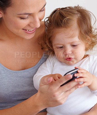 Buy stock photo Cellphone, playing and mom with baby on bed for bonding and watching video on social media together. Happy, love and young mother scroll on a phone with girl child, kid or toddler in bedroom at home

