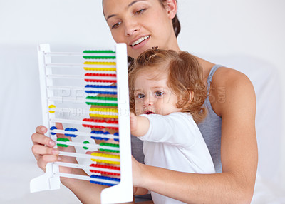 Buy stock photo Abacus, playing and girl baby with mother for math, learning and teaching for child development on bed. Bonding, toy and young mom with kid, infant or toddler with counting in bedroom at home.