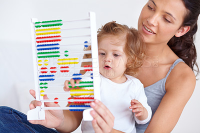 Buy stock photo A mother and her baby daughter playing with an abacus